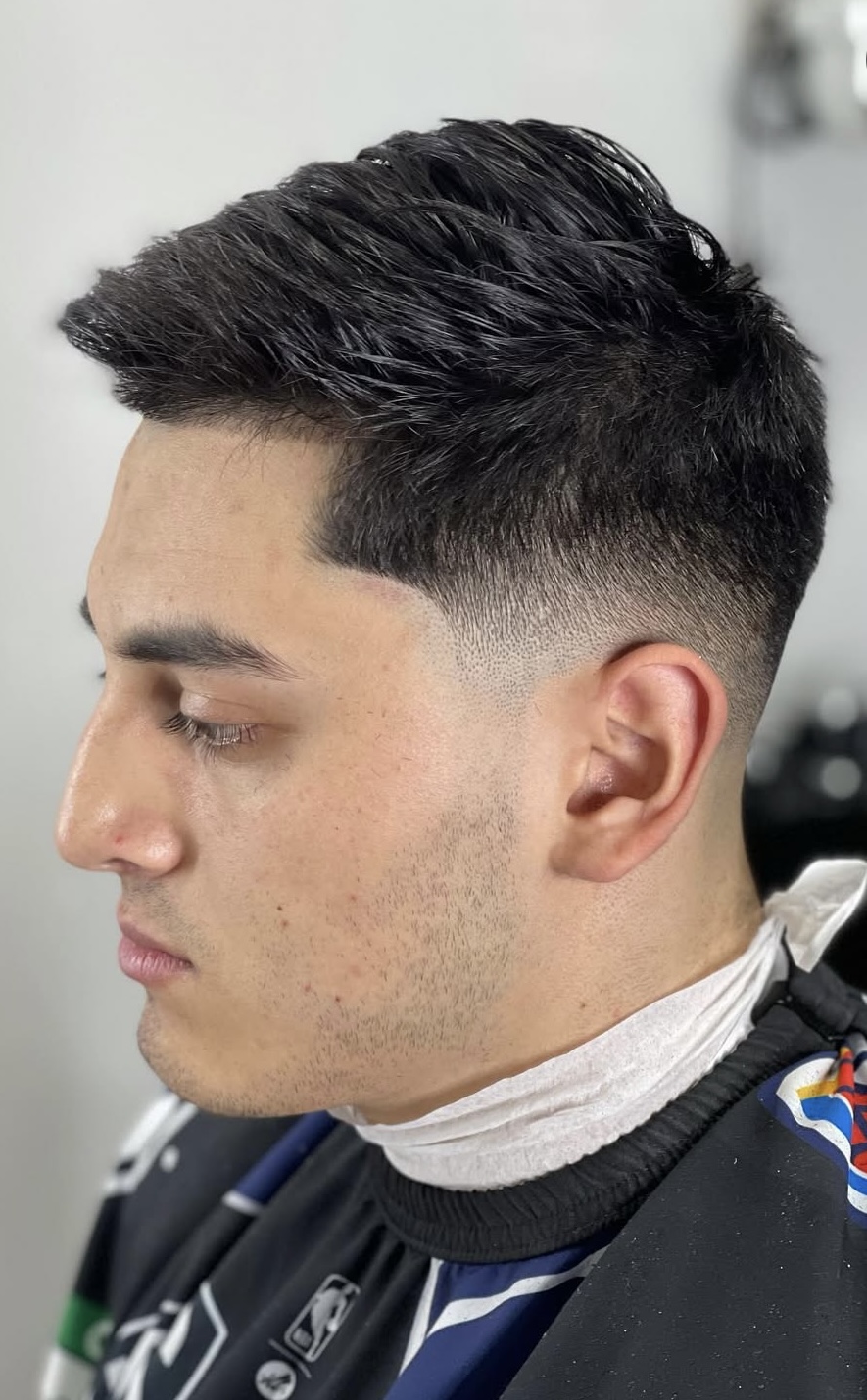 Low fade with textured top and clean lineup by Sharp Society Barbershop